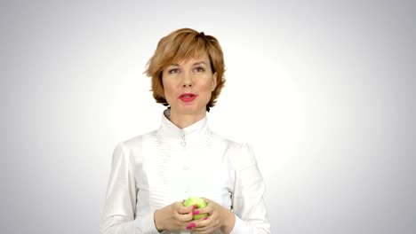 Portrait-of-young-woman-eating-green-apple-on-white-background