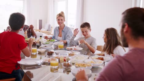 Zwei-Familien-genießen-Mahlzeit-im-Hause-zusammen-Schuss-In-Zeitlupe