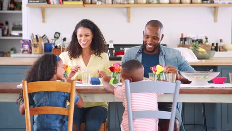 Schwarze-Familie-von-vier-reden-beim-Mittagessen-in-der-Küche