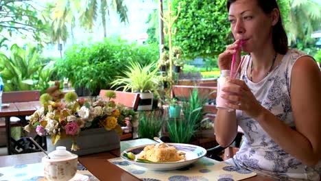 Woman-drinking-a-milkshake-at-a-restaurant