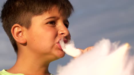 Junge-kaukasischen-Essen-süße-Zuckerwatte-gegen-den-Himmel