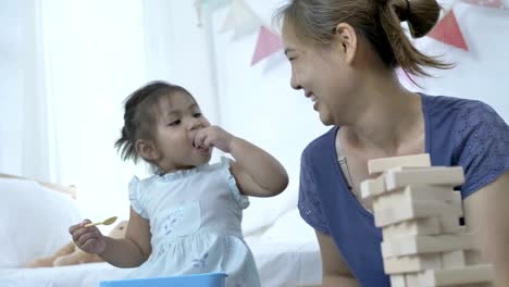 4K:-glückliches-asiatischen-Kind-füttern-Kartoffel-Chips-für-die-Mutter