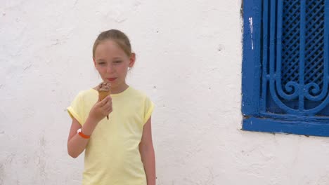 Adolescente-de-niña-retrato-comiendo-helado-de-chocolate-sobre-fondo-de-pared-blanca