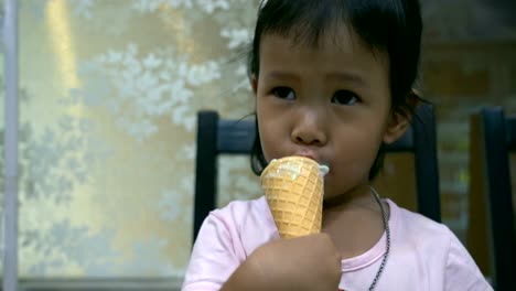 Kid-is-eating-rainbow-ice-cream-cone.