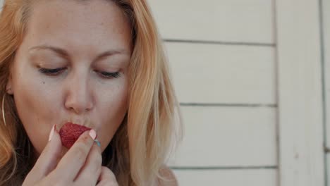 Portrait-woman-enjoying-the-taste-of-ripe-strawberries-close-up