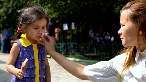 A-young-woman-is-wiping-her-daughter's-face.