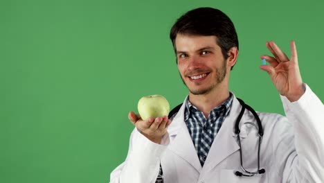 Fröhliche-männlichen-Arzt-hält-Vitamin-Pille-und-einen-Apfel