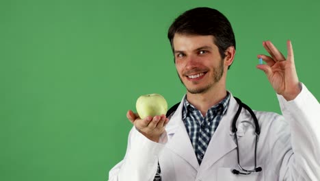 Cheerful-male-doctor-holding-vitamin-pill-and-an-apple