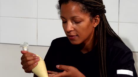 Hermosa-mujer-madura-chocolatier-sonriendo-a-la-cámara-mientras-se-trabaja