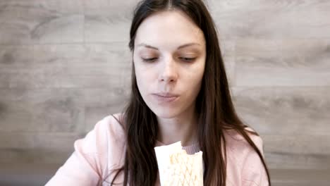 Junge-Brünette-Frau-Essen-Danar-oder-Shawarma-sitzen-in-einem-Café.