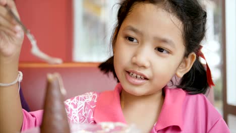 Slow-motion-Asian-little-girl-is-eating-ice-cream-with-happiness