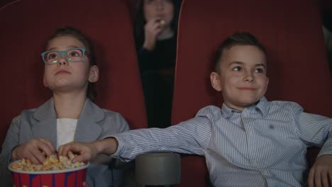 Kinder-essen-Popcorn-im-Kino.-Kinder-im-Vorschulalter-Film-im-Kino