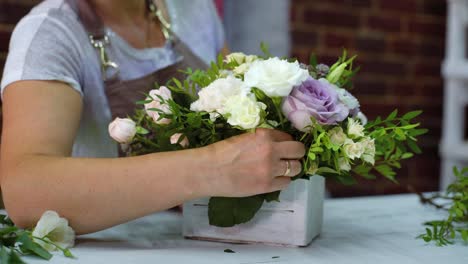 professionellen-Floristen-arrangieren-schöne-Blume-Zusammensetzung-in-Holzkiste-im-floralen-Designstudio