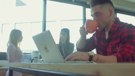 Man-drinks-coffee-while-working-in-the-startup-office