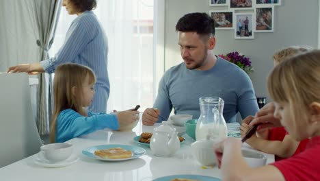 Family-of-Five-Talking-while-Having-Breakfast