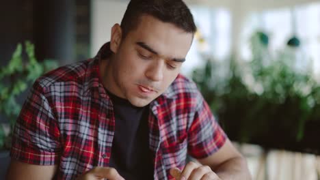 un-hombre-en-una-camisa-a-cuadros-es-comer-deliciosa-pizza-en-una-pizzería-en-la-tarde