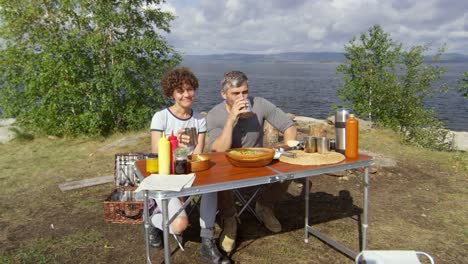 Entspannte-Paar-genießt-Picknick-am-See