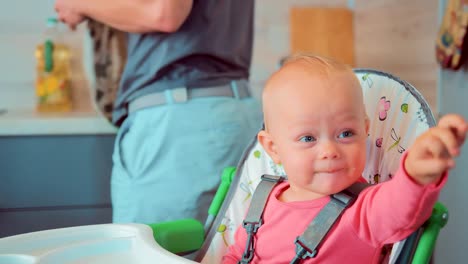 Careful-dad-wipes-his-face-and-hands-from-the-porridge-of-his-child-after-feeding