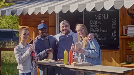 Gruppe-von-fröhlichen-Menschen-stehen-in-der-Nähe-von-Straßenküchen-Anhänger