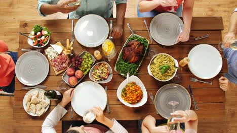 Gruppe-von-Menschen-Essen-und-trinken-Wein-am-Tisch