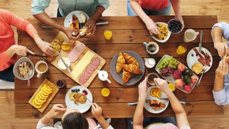 Gruppe-von-Menschen,-die-Essen-am-Tisch-mit-Essen