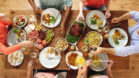 Grupo-de-personas-que-comen-en-la-mesa-con-la-comida