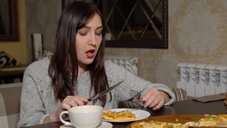 Pizzeria.-A-brunette-woman-eating-pizza-at-a-cafe