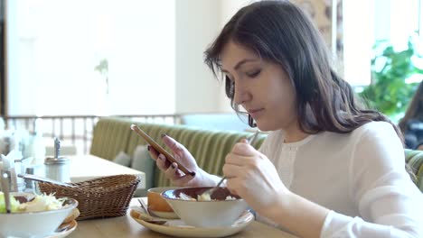 Junge-Frau-in-Café-mit-Telefon.-Mittagspause