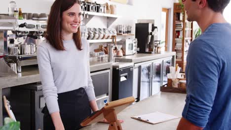 Man-making-contactless-smartphone-payment-at-a-coffee-shop