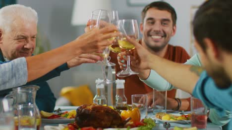 Big-Family-and-Friends-Celebration-at-Home,-Diverse-Group-of-Children,-Young-Adults-and-Old-People-Gathered-at-the-Table-have-Fun-Conversation.-Clinking-Glasses-and-Making-Toast.-In-Slow-Motion.