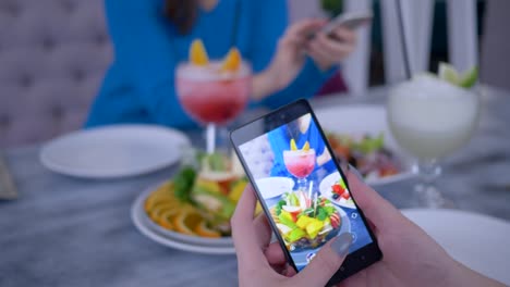 smart-telephone-in-blogger-woman-hand-makes-photo-healthy-vegetarian-eating-during-lunch-for-social-networks,-close-up