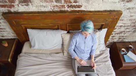 Hipster-Woman-Sitting-on-Bed-and-Working-on-Laptop