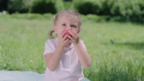 Nutrición-saludable.-Niño-comiendo-jugosa-manzana-al-aire-libre