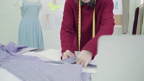 Profesional-hermosa-asiática-mujer-diseñadora-de-moda-trabajando-con-bocetos-de-la-tela-y-dibujo-diseño-de-ropa-en-el-estudio.-Mujeres-del-estilo-de-vida-que-trabajan-concepto.