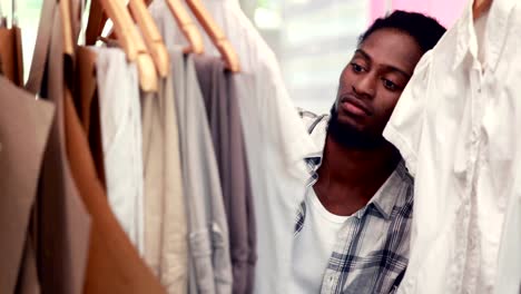 Male-fashion-designer-looking-at-rack-of-clothes