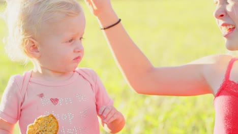 Cute-blonde-Kleinkind-draußen-in-der-Sonne-mit-cracker