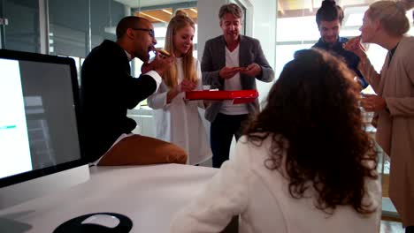 Head-of-department-handing-out-pizza-during-a-office-meeting.