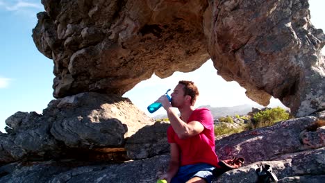 Escalador-hombre-comiendo-manzana-durante-el-resto-de-extrema-roca-escalada