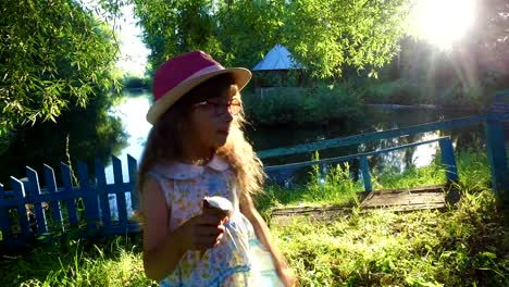 Little-girl-with-long-hair-eats-ice-cream-in-the-park.