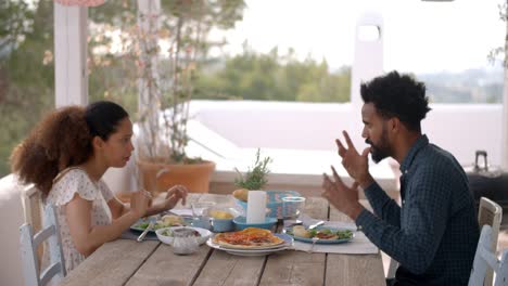 Couple-Enjoying-Outdoor-Meal-On-Terrace-Together