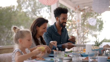 Familien-genießen-Outdoor-Essen-auf-Terrasse-gemeinsam