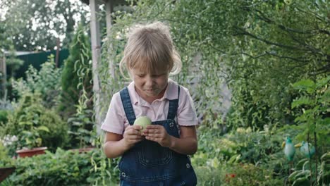 Mädchen-essen-sauren-Apfel-im-Green-Garden