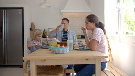 Familie-herumsitzen-Küchentisch-Essen