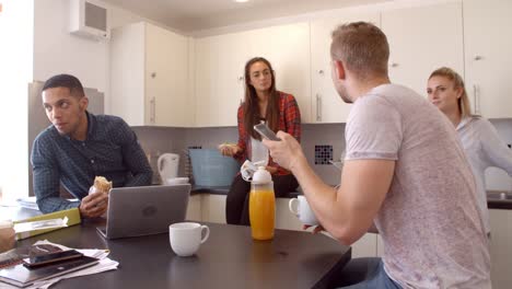 Students-Relaxing-In-Kitchen-Of-Shared-Accommodation