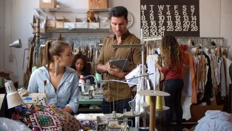 Colegas-que-hablan-en-un-taller-de-fabricación-de-ropa