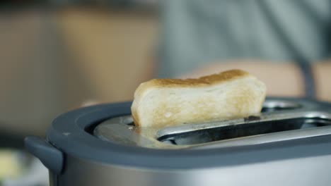 Nahaufnahme-einer-Frau-nehmen-Toast-aus-einem-Toaster.