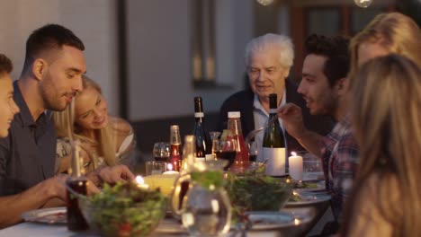 Group-of-Mixed-Race-People-Having-fun,-Communicating-and-Eating-at-Outdoor-Family-Dinner