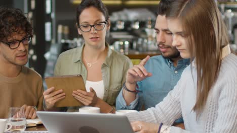 Small-Creative-Team-of-Active-Young-People-Having-Meeting-and-Discussion-in-Coffee-Shop.