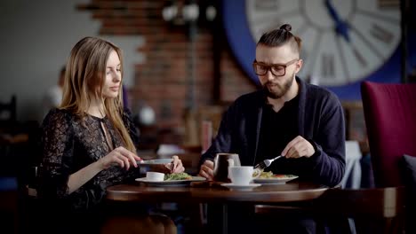 Ein-paar,-ein-Mann-und-eine-Frau-in-einem-modernen-Restaurant-haben-Mittag--oder-Abendessen.-Ein-Mann-und-eine-Frau-Essen-genießen-und-haben-eine-gesellschaftliche-Unterhaltung.-In-der-Liebe-lachen-sie,-weil-sie-ein-Date-haben