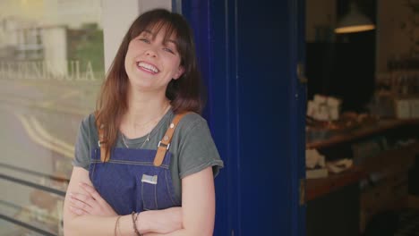 Portrait-Of-Cheerful-Deli-Owner-Standing-Arms-Crossed-Outside-Shop